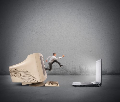 Businessman Jumping From Old Computer to New Computer